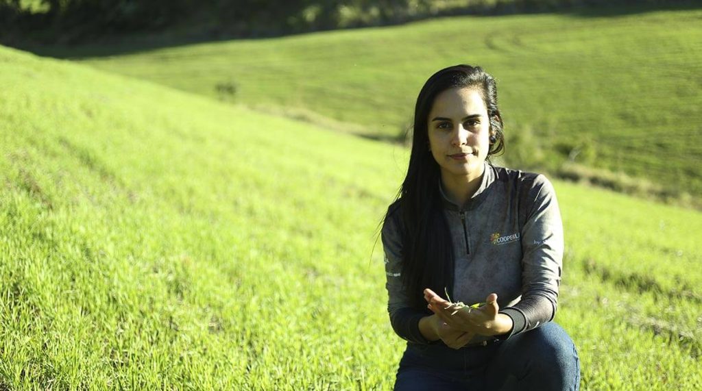 Assistente técnica da cooperlate na lavoura de pasto com mudas na maõ