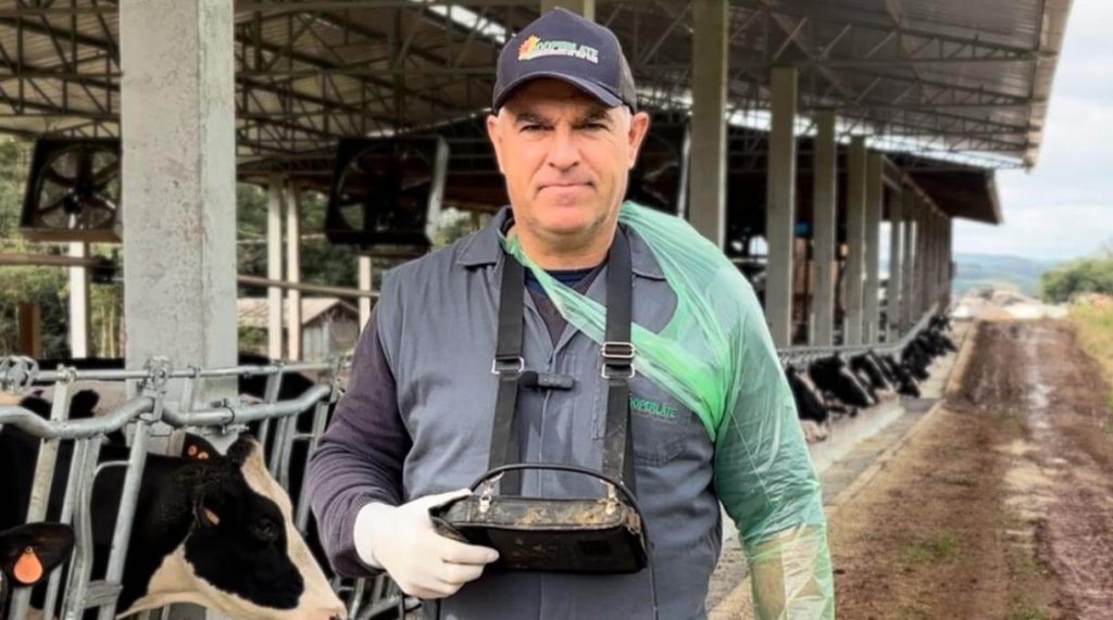 médico veterinario da cooperlate em frente um rebanho de vacas leiteiras em confinamento